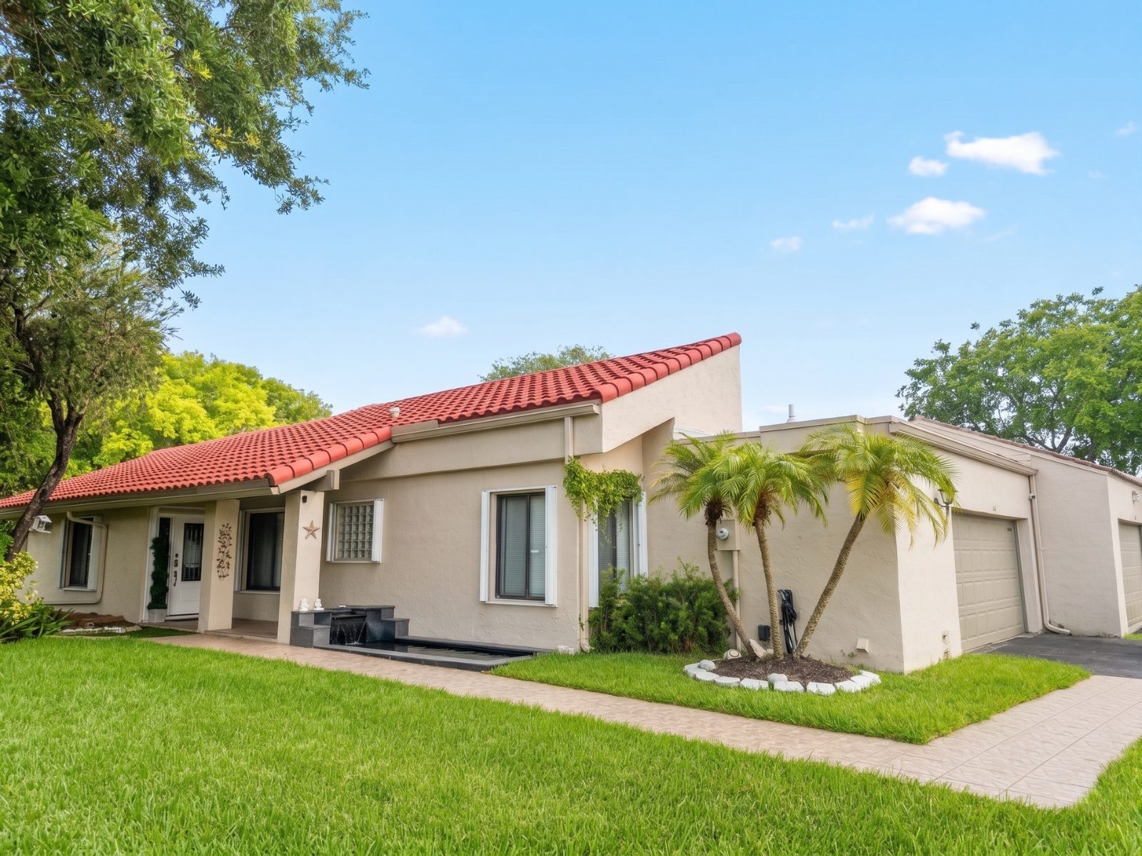 Single-story home with a tile roof and palm trees in southwest Broward